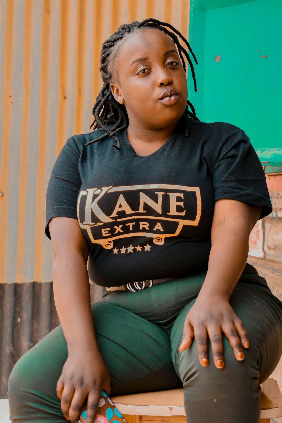 woman in black and yellow crew neck t-shirt sitting on green plastic chair